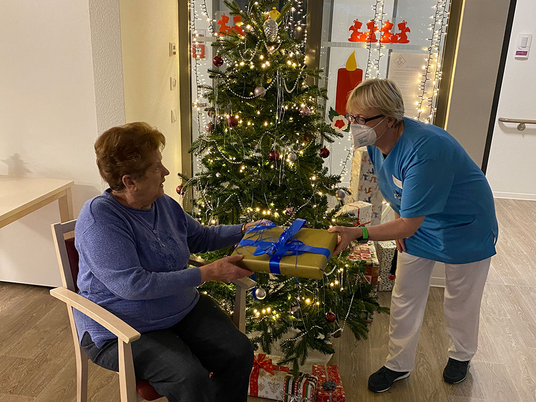 Immanuel Seniorenzentrum Elstal | Betreuerin Corinna Janicke übergibt ein Puzzel an eine Bewohnerin